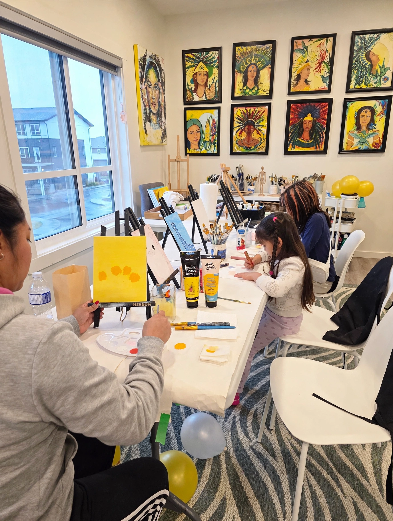 Children painting on canvas at the studio table during an ArtMuse art session
