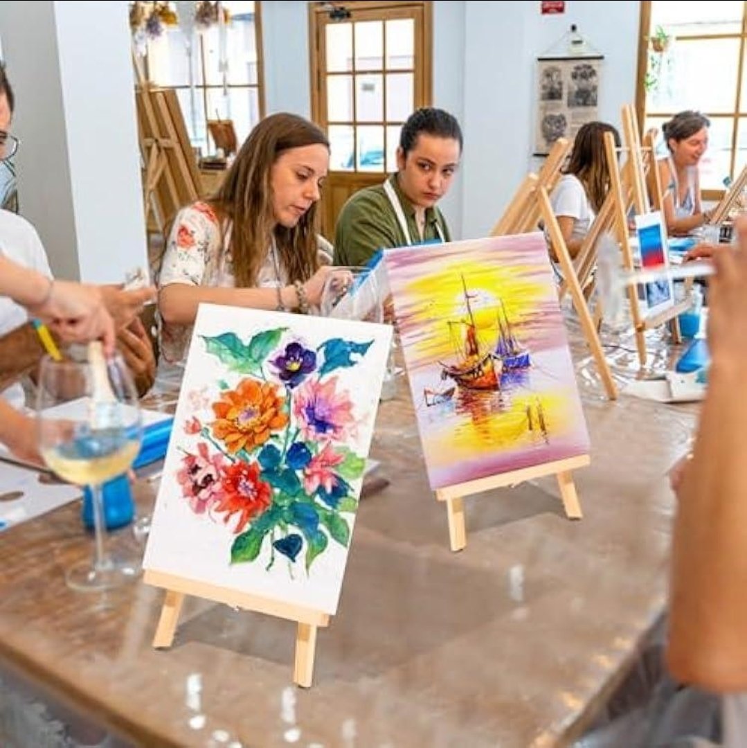 Adults painting on canvas at table easels in a morning acrylic painting workshop